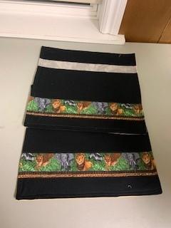 A pair of black and green fabric with animals on it

Description automatically generated with medium confidence