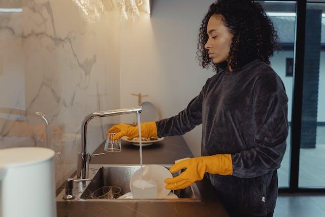 a woman pouring grease down the drain.