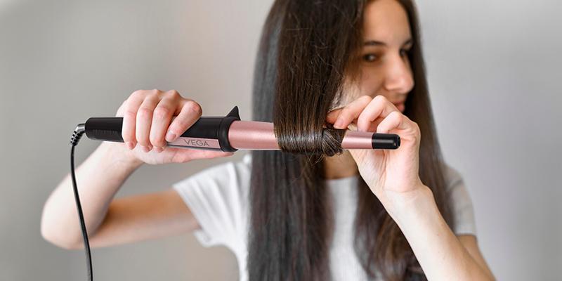 A person curling her hair

Description automatically generated