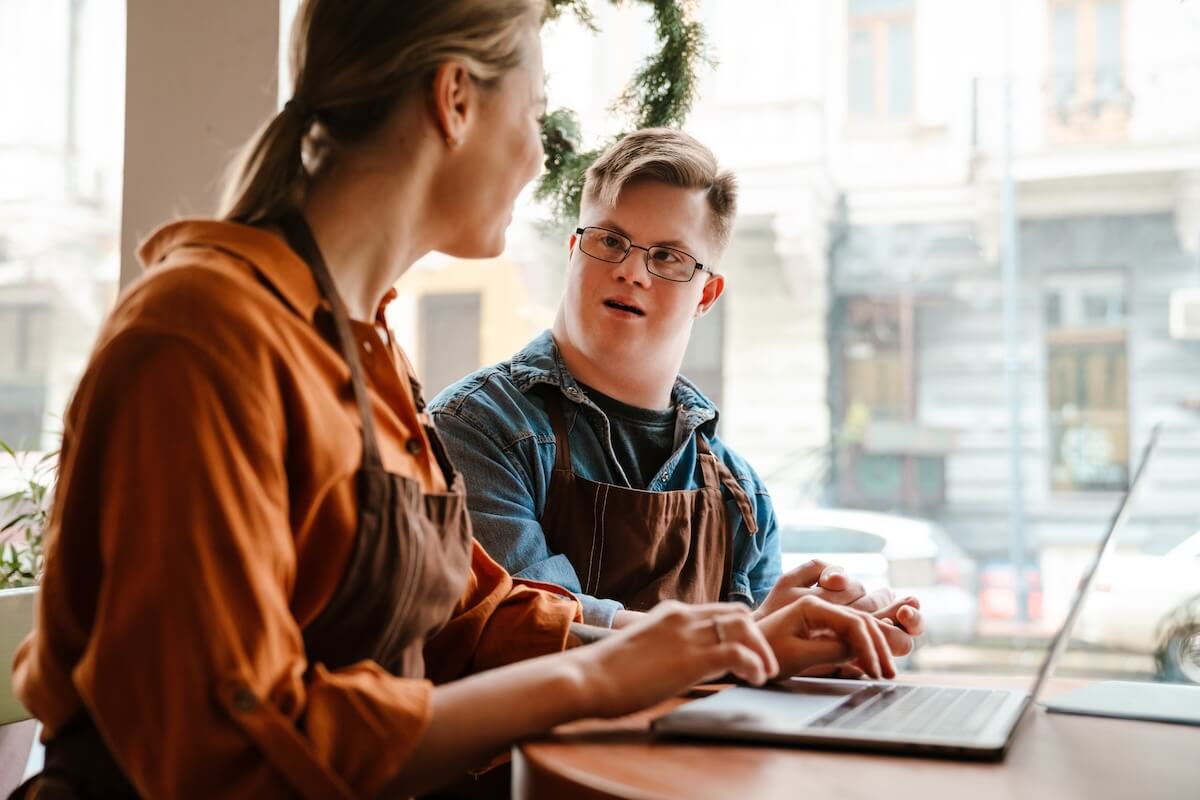 ADA effective communication: man with Down syndrome talking to his co-worker