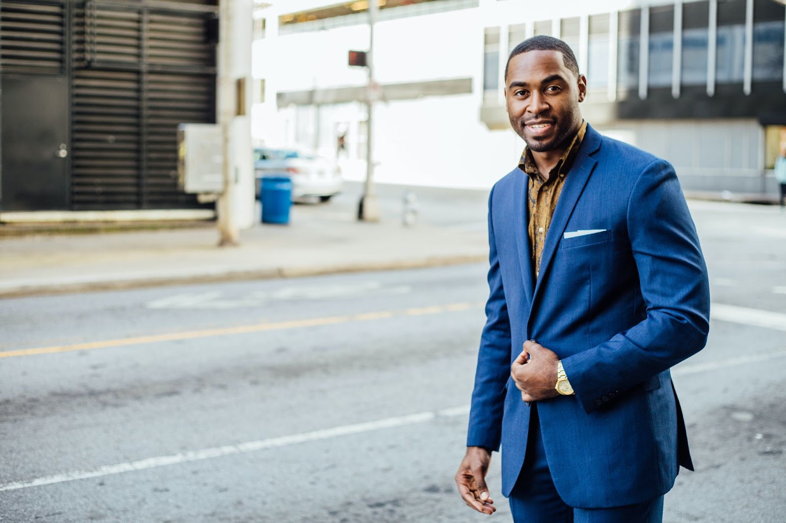 A man dressed in formals in an outdoor setting posing for the camera for a photoshoot