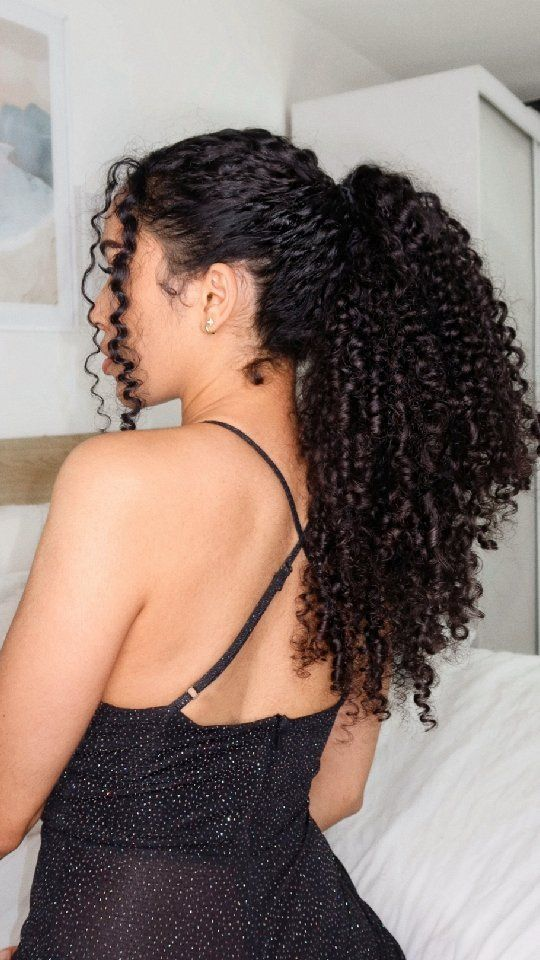 Picture showing a lady rocking a updo with tendrils on her 3b hair 
