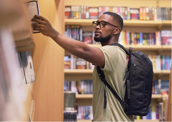 A man checking books in a bookshop