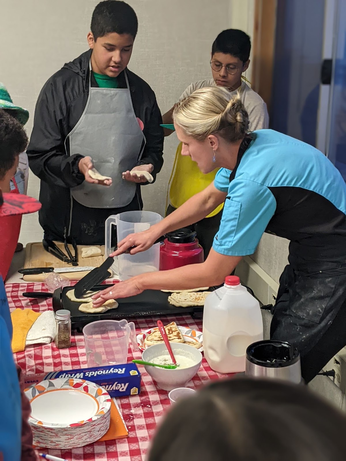 A woman making food at a table . 