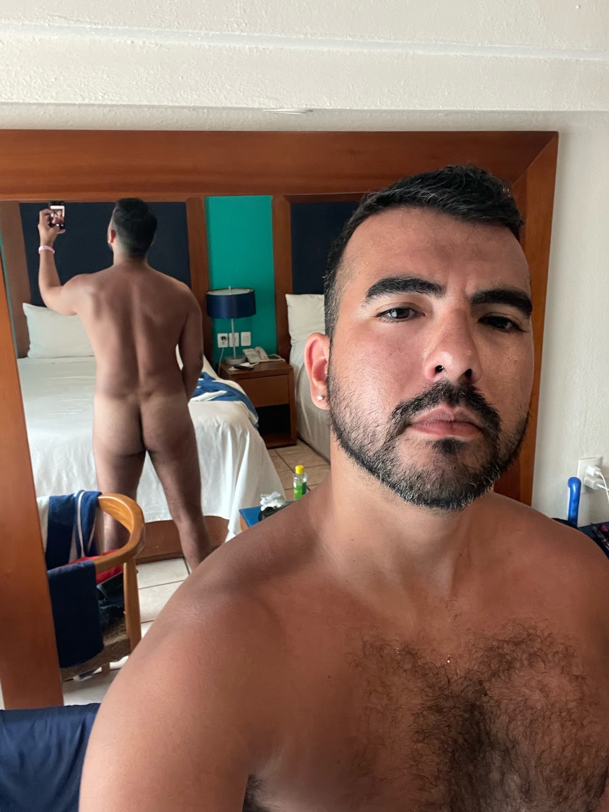 gay male wearing nothing in mexico PV hotel room taking a mirror iphone selfie 