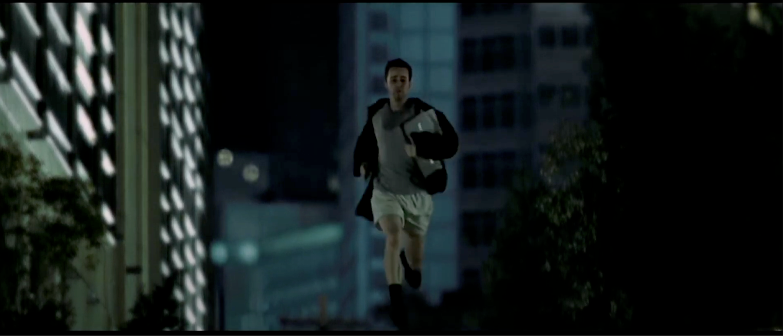 The Narrator in Fight Club runs down the street holding several folders. 