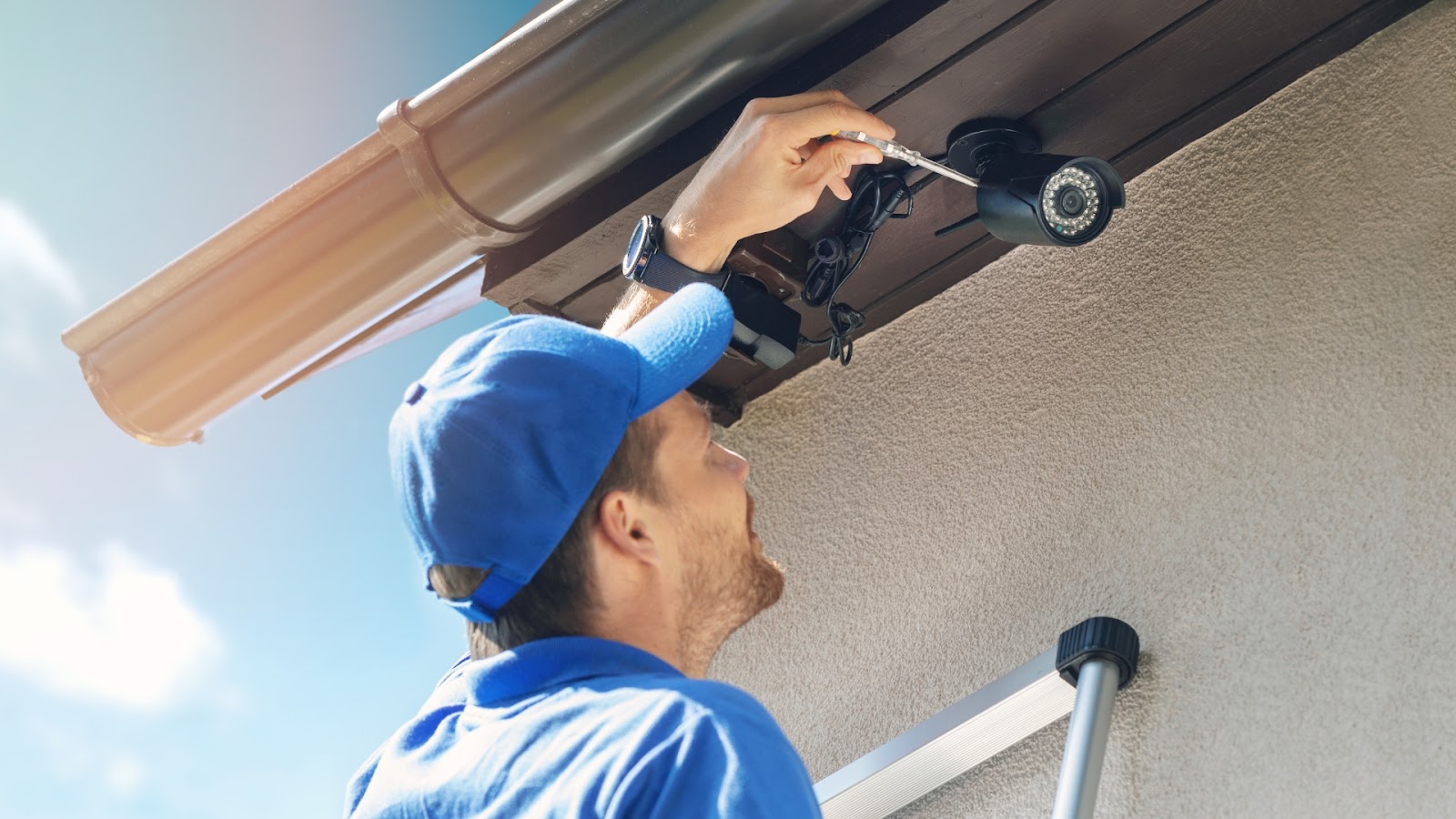 A technician installing CCTV cameras around the garage door