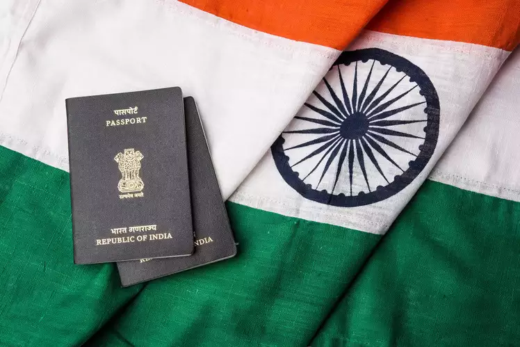 An Indian passport resting on top of an Indian Flag