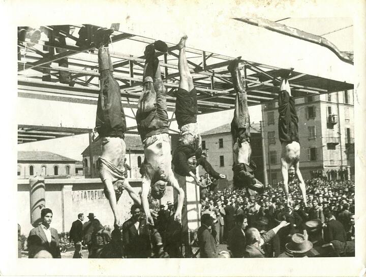 Тела Бенито Муссолини (второе слева) и его любовницы Клары Петаччи (в центре), вывешенные после их казни на центральной площади Милана. 1945 год. Фото: Vincenzo Carrese, Public Domain, commons.wikimedia.org