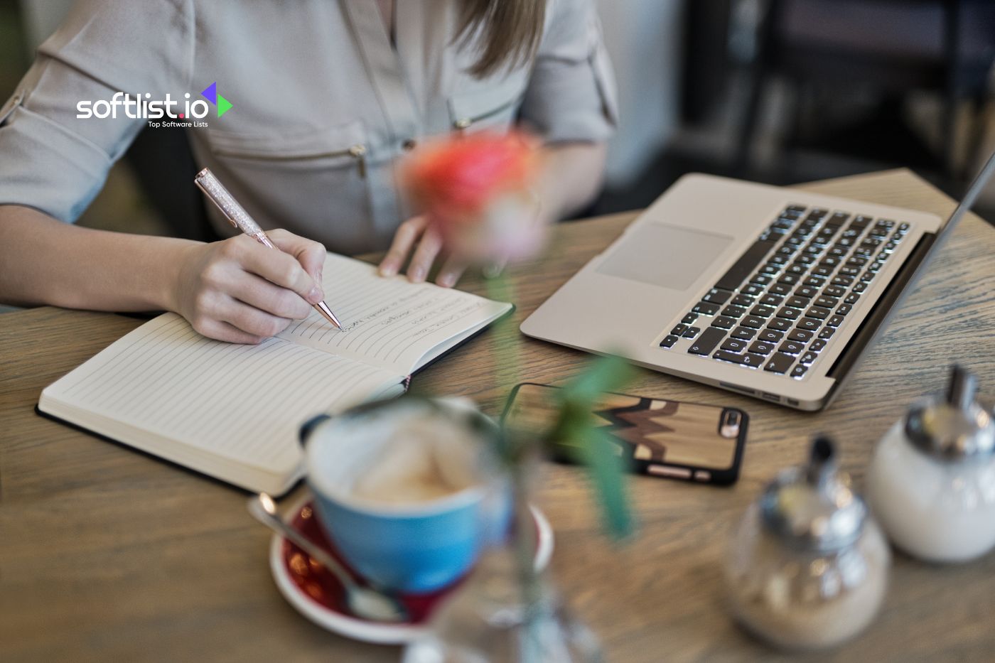 a woman writing with her notebook and with laptop