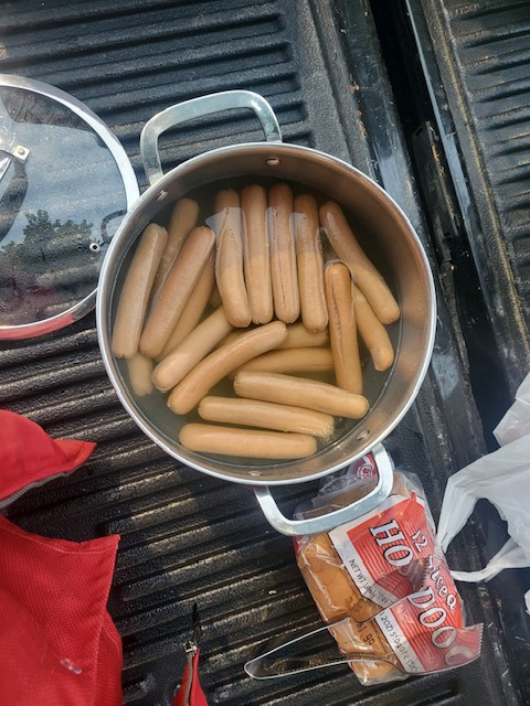 Hot dogs in a pot on a grill

Description automatically generated