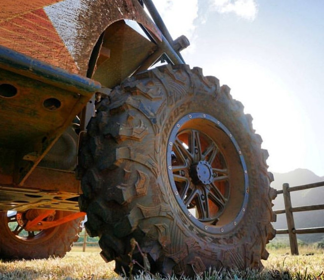 A low-angle image looking up at the tire and wheel well of a Polaris Xpedition XP.