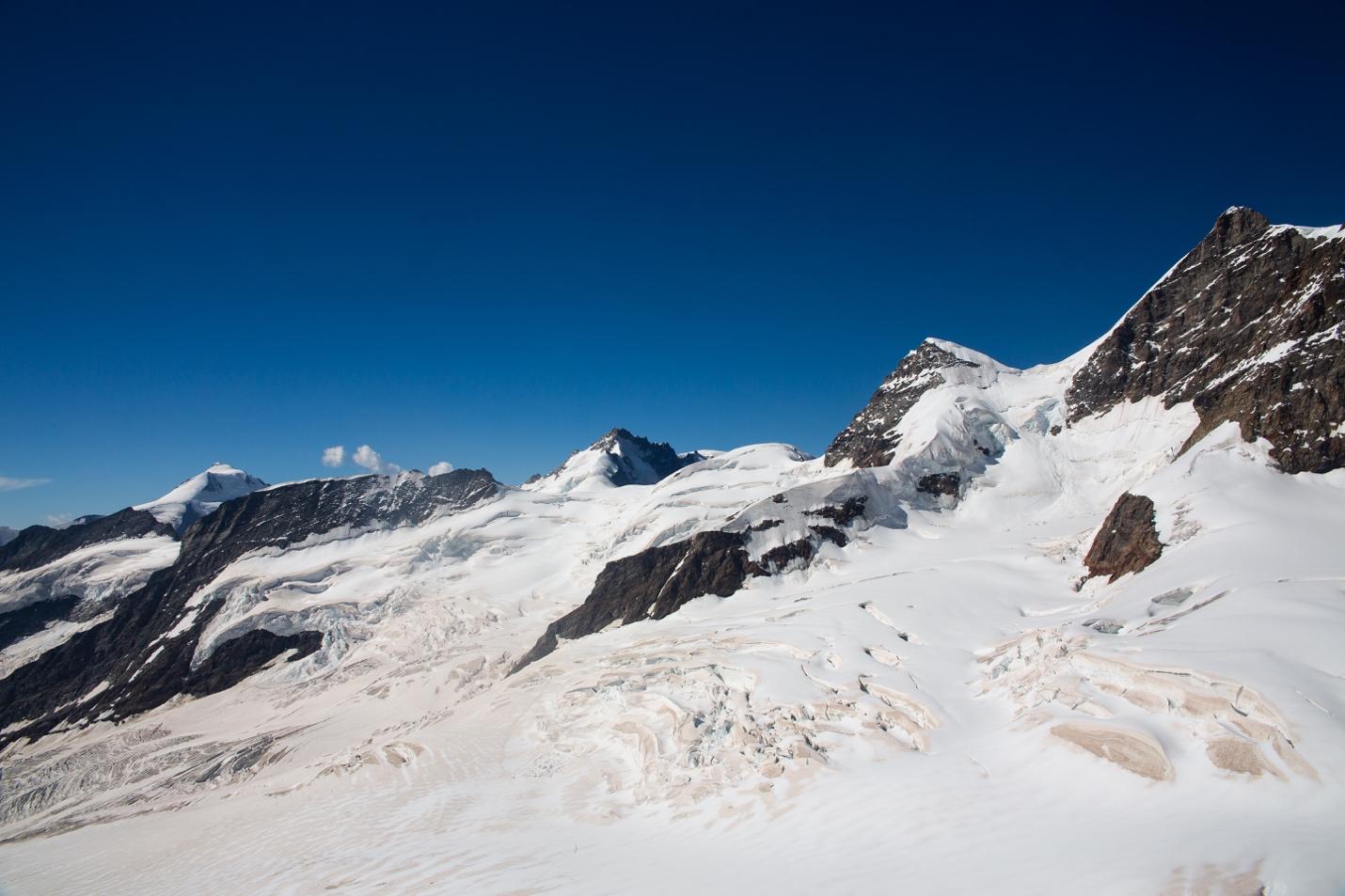 A snowy mountain range with blue sky

Description automatically generated