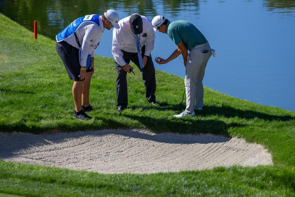 golfers investigating bunker golf ball