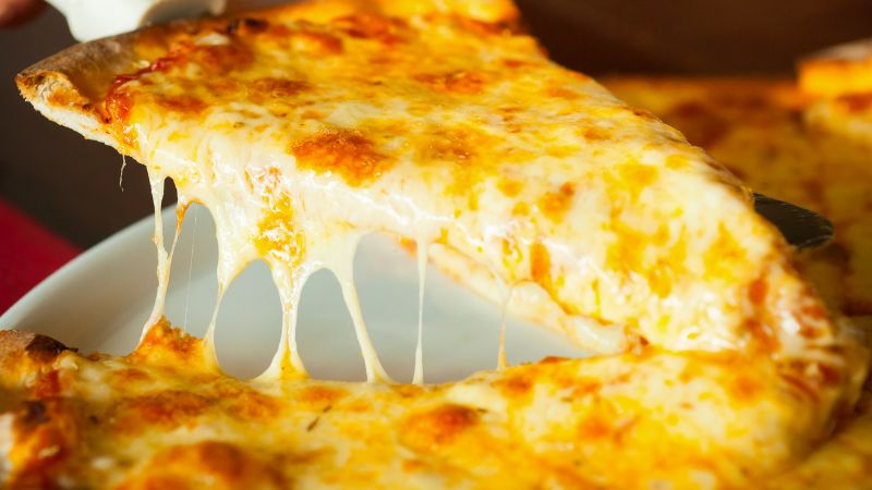 The golden, tantalising pizza is cut into pieces