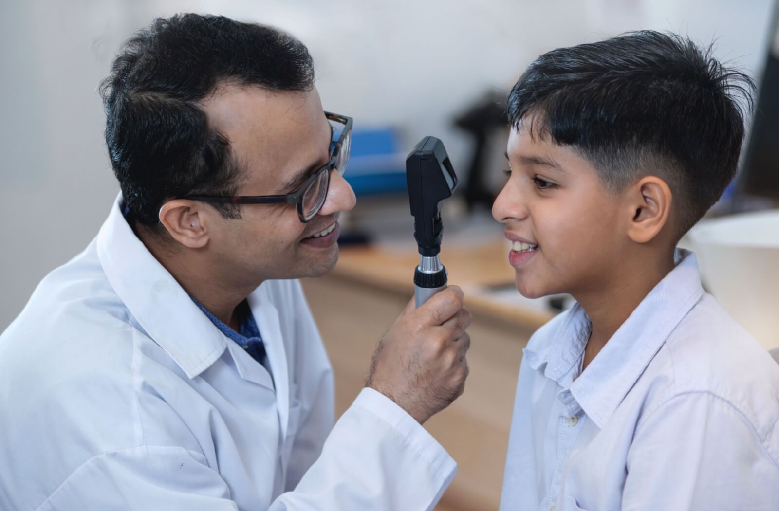 An optometrist checking the eye of a child for signs of myopia.
