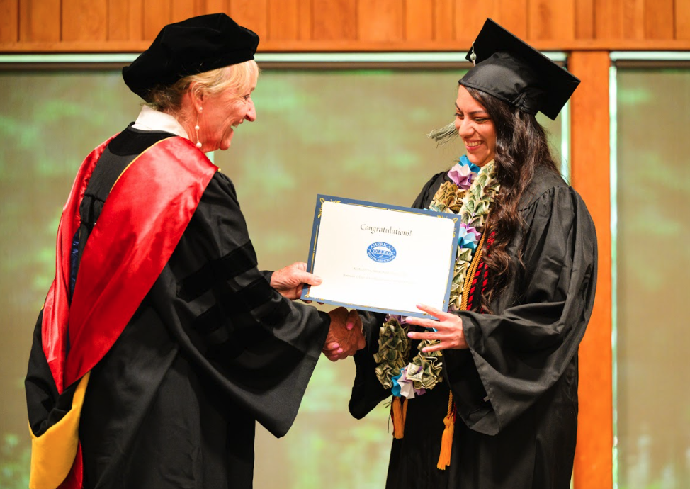 Janet Ludwig presents an ACHS graduate with their degree