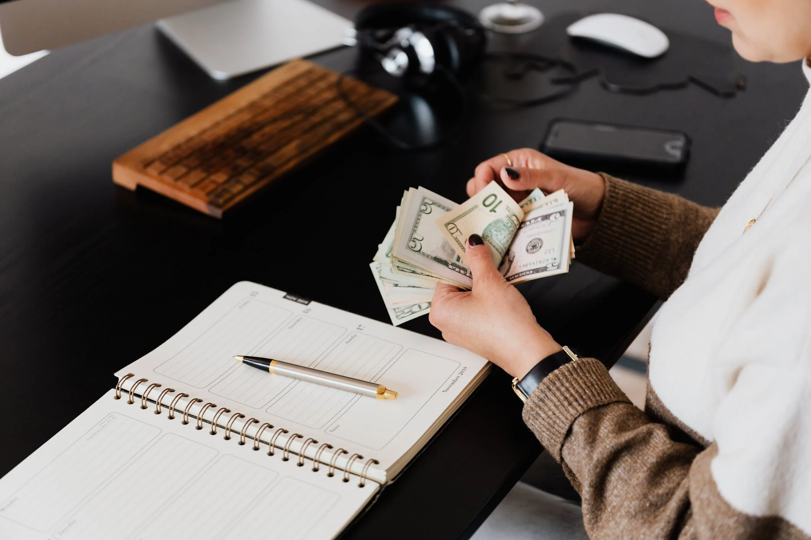 A woman counting dollar bills
