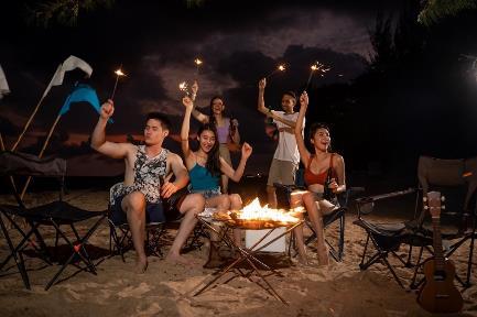 A group of people sitting around a fire

Description automatically generated