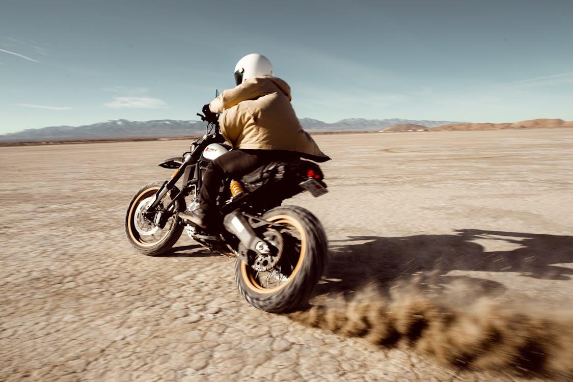 Free Person Riding Bike Through Desert Stock Photo