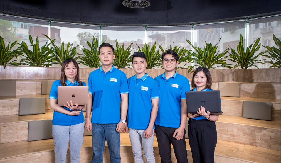 A group of people in blue shirts holding laptops

Description automatically generated