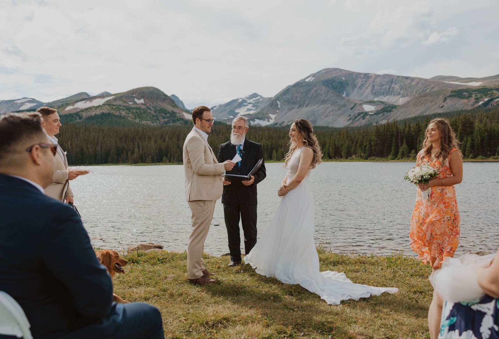 couple exchanging vows in front of Lake Isabelle