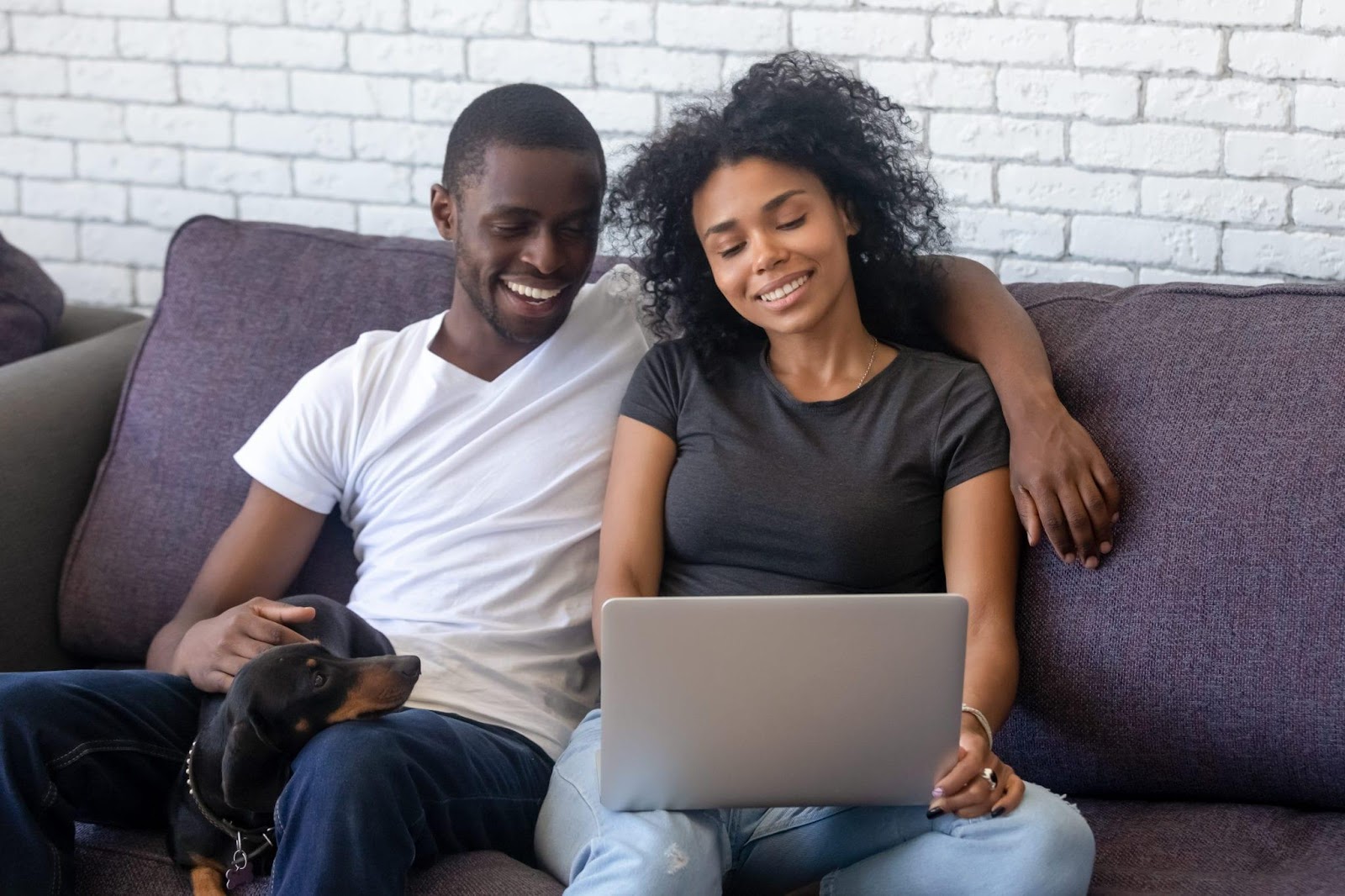 Happy black couple using laptop relaxing with pet at home - Georgia Health  Policy Center