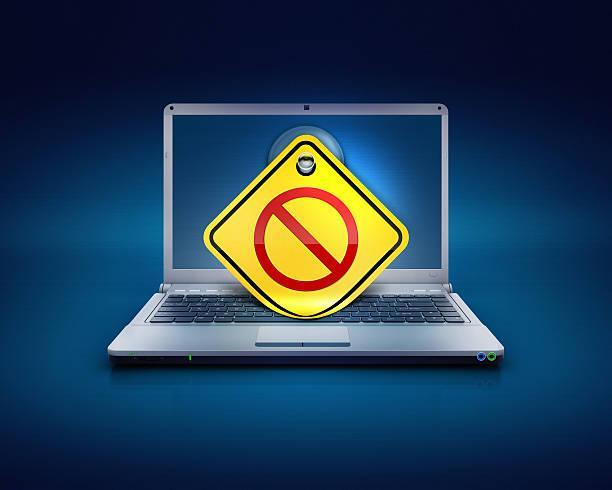 noentry or blocked no access sign on computers pc computer laptop screen on a blue background with sticky note showing the traffic sign of no entry for no access networks or blocked website etc.. Concept of internet security, maleware and antivirus protections on a PC. IP Bans stock pictures, royalty-free photos & images