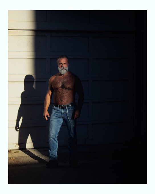 Daddy John standing in a poloroid photo in jeans shirtless showing off his hairy muscled chest