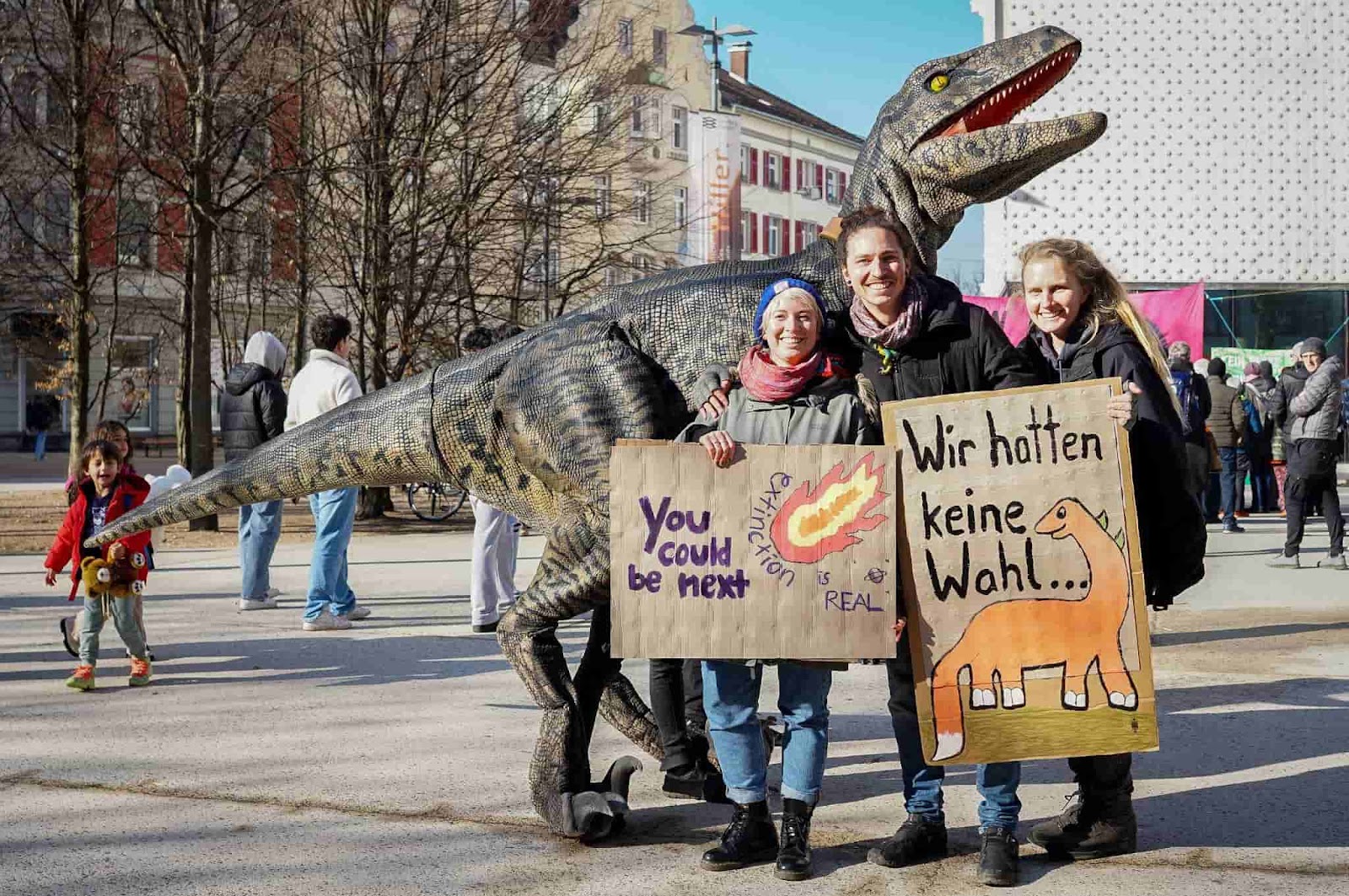 Rebels pose beside a life size raptor dinosaur.
