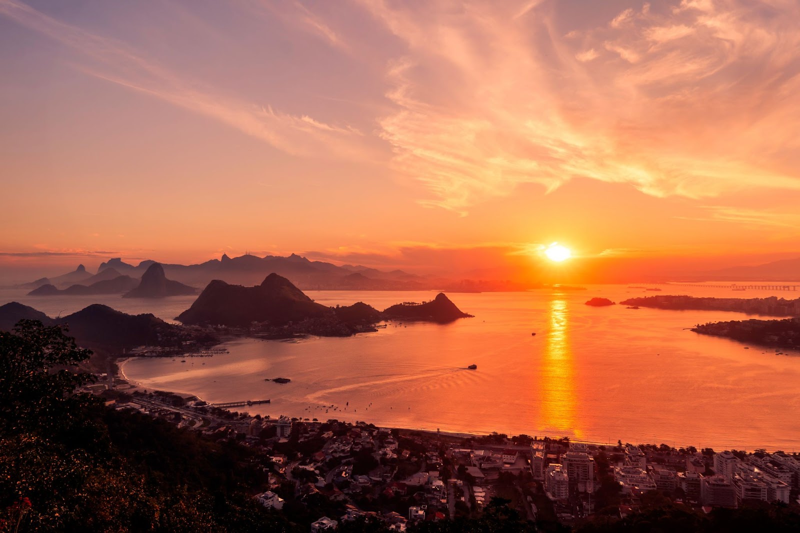 Vista do pôr do sol em paisagem da cidade de Niterói, colorindo a Baía de Guanabara.