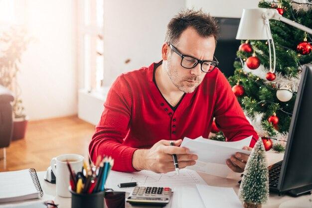 Photo man sitting at the office desk and reading letter