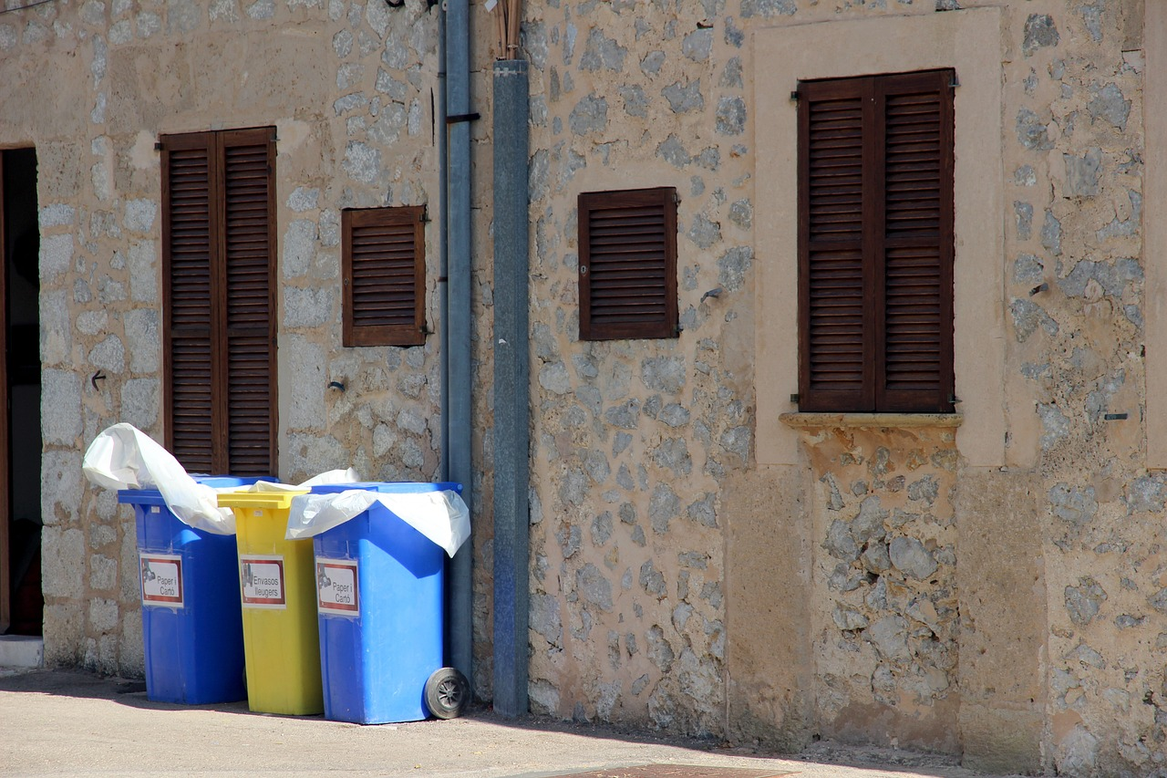 trash cans with liners sitting against a building