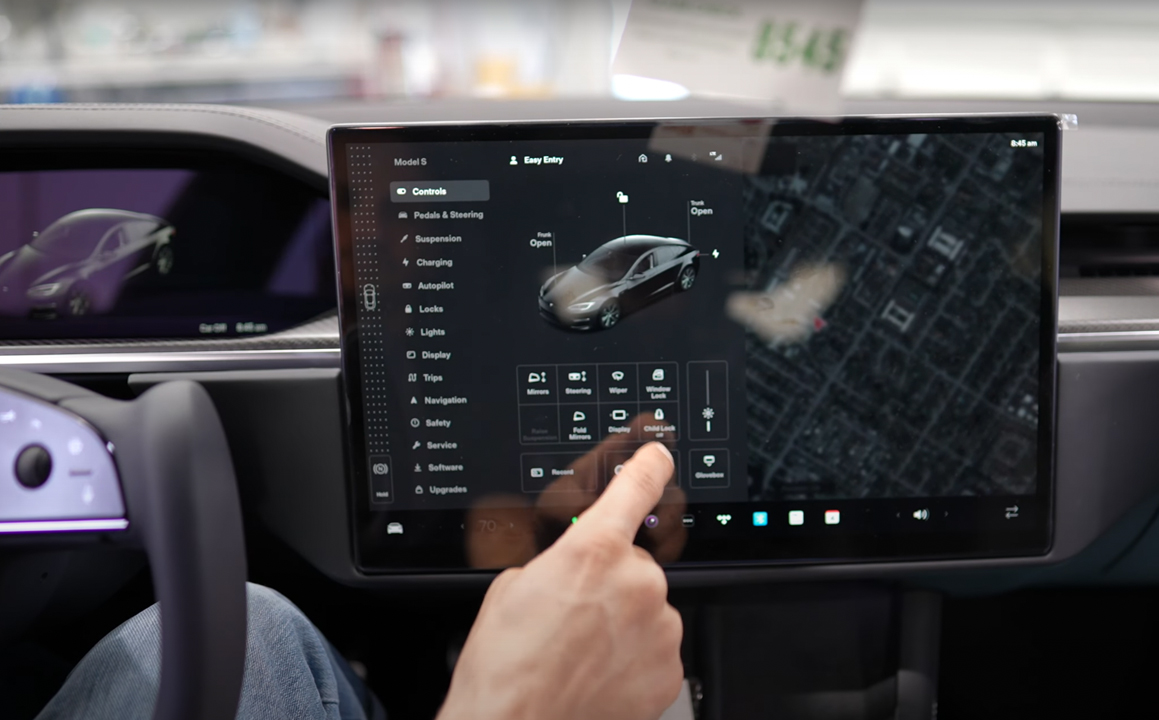Driver using a Tesla touch-screen panel from the driver’s seat
