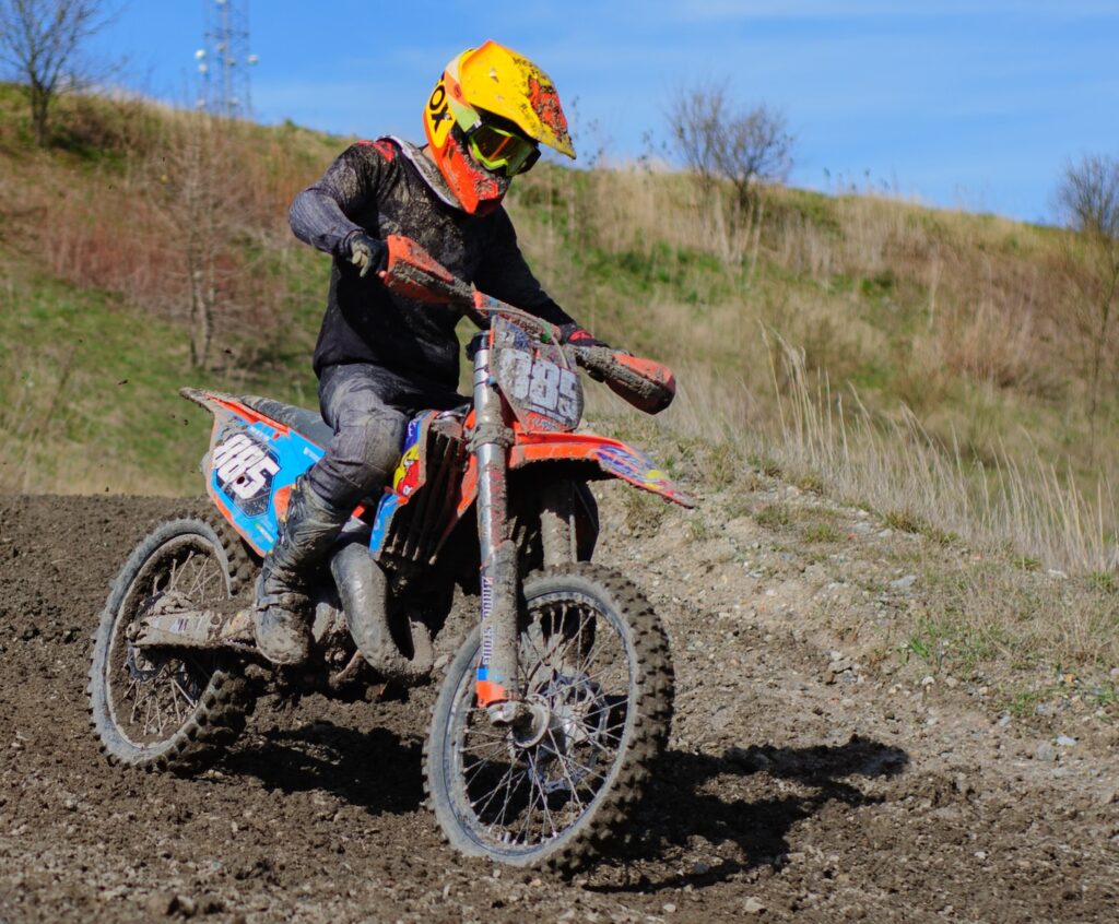 a man riding a dirt bike on top of a dirt field