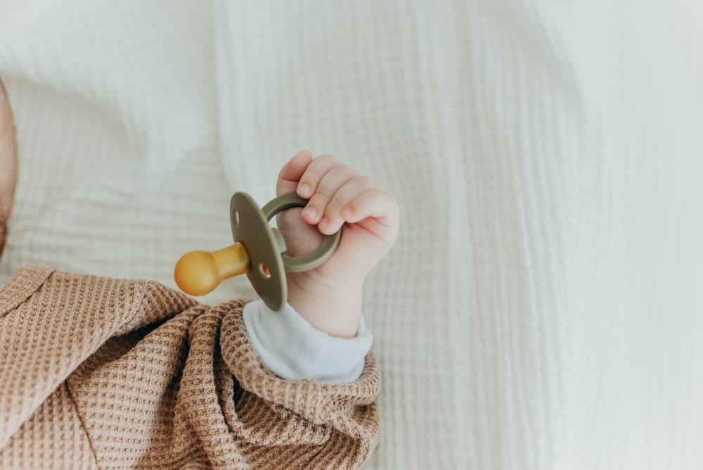 baby holding pacifier