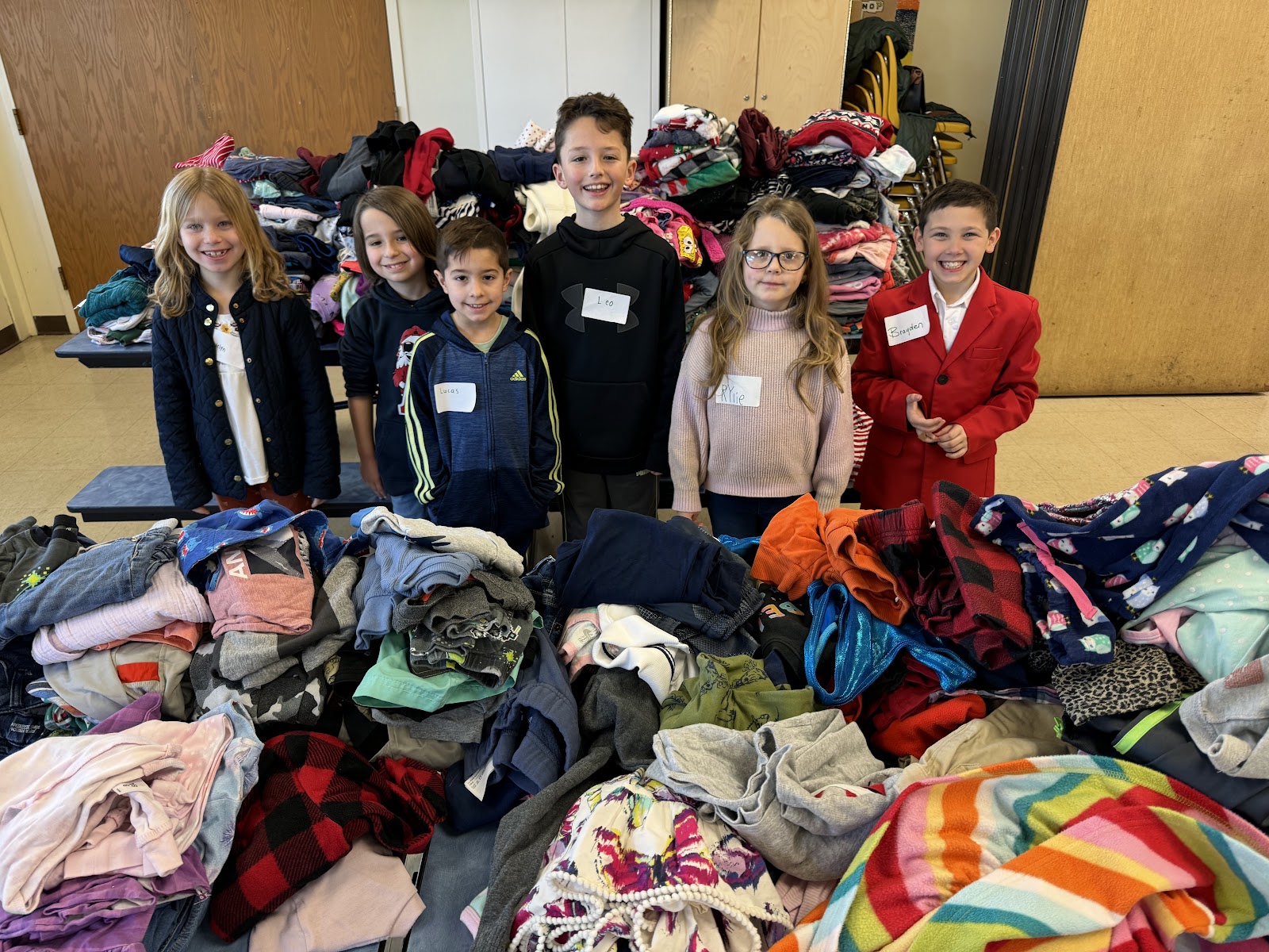 image of students posing with clothing collected during the AES open house clothing drive