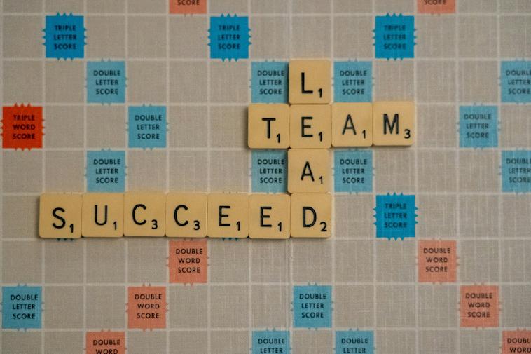 Scrabble tiles that spells the following words: "Lead," "Team," and "Succeed." These are common themes used by ex-Marine motivational speaker in their speeches.
