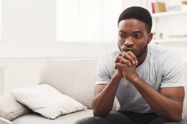 Disappointed Young Africanamerican Man At Home Stock Photo - Download Image  Now - Men, Sadness, Contemplation - iStock