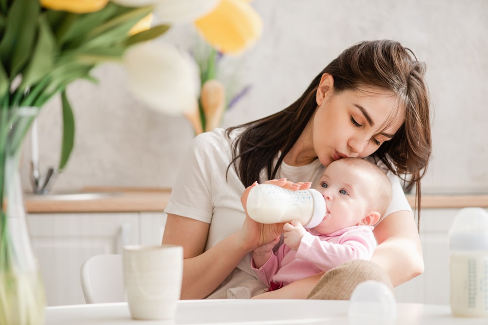 mother feeding a baby with baby bottle 