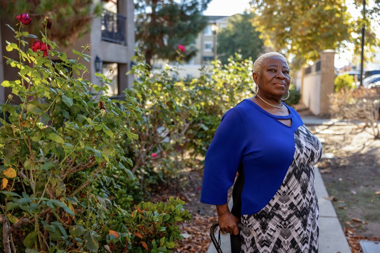 Nancy Wiles stands in front of her former apartment building in Oakley on Dec. 4, 2023. Wiles, who is originally from Liberia, moved in in 2014 and endured constant leaks and flooding in her building. When she fell behind on her rent, she received an eviction notice and moved out this September. Photo by Manuel Orbegozo for CalMatters