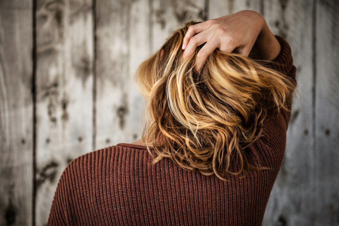 Een vrouw die haar handen door haar haar haalt. 