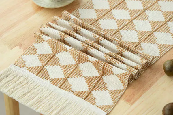 Medium handcrafted linen table runner with a brown and beige diamond pattern and adorned with tassels