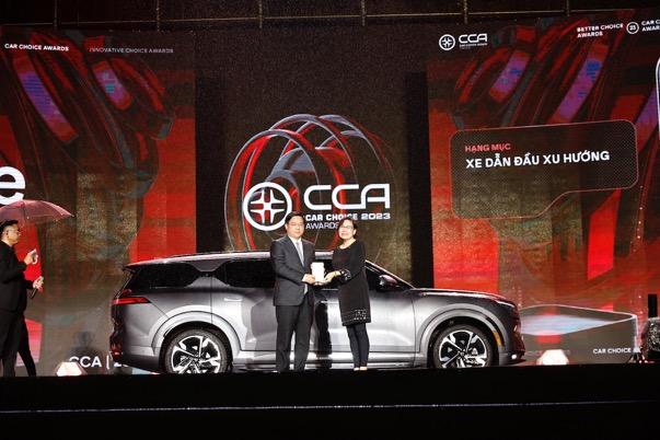 A person and person on stage with a car

Description automatically generated