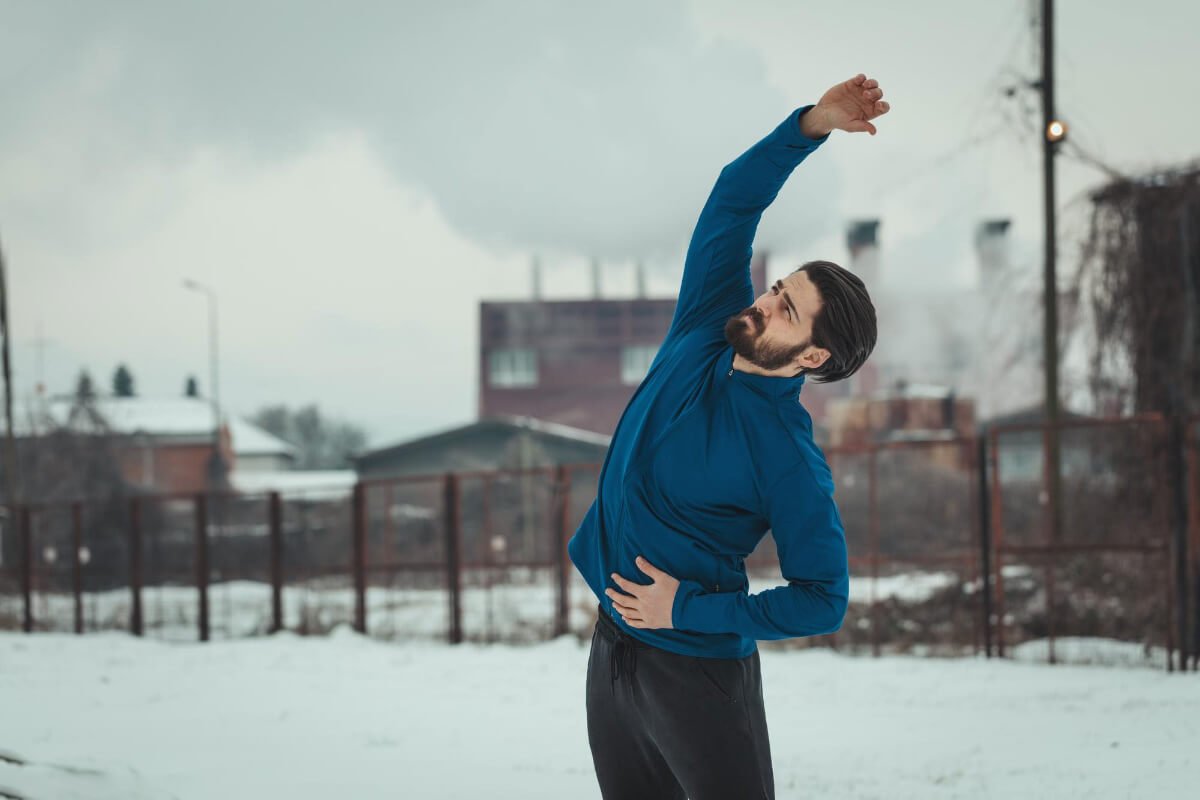 homem se aquecendo para treinar no inverno