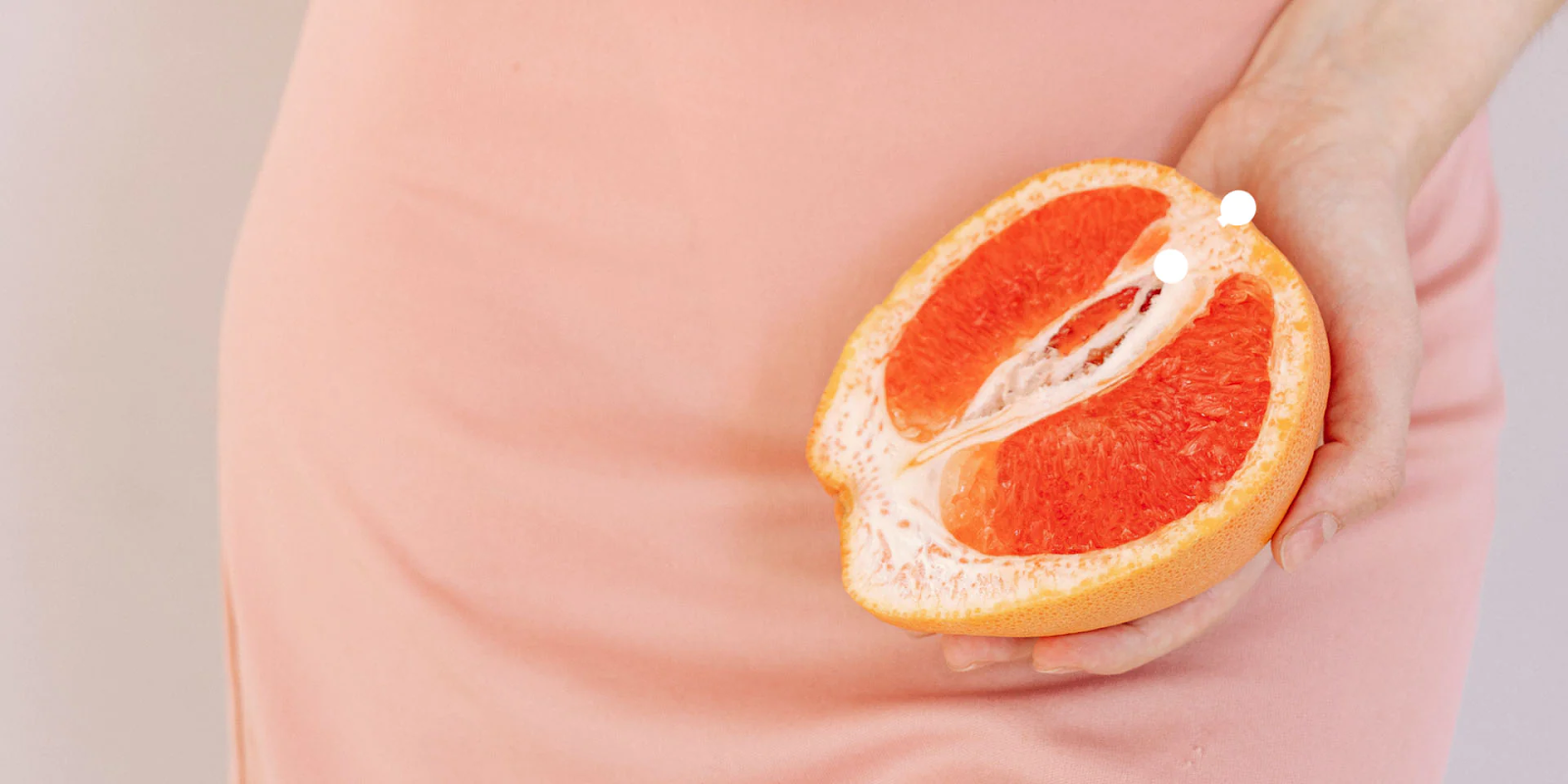 Picture of a lady holding a symbolical orange that resembles women's lady parts