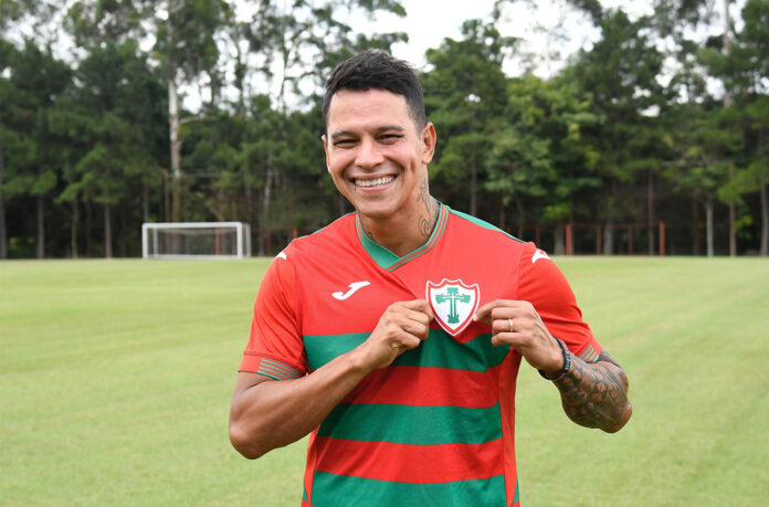 Giovanni Augusto reforça a Portuguesa para 2024 e posa com a camisa do clube para uma foto oficial