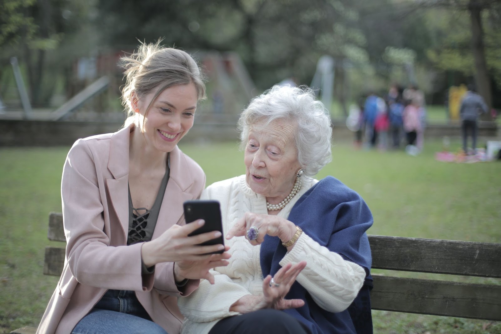 A young adult showing a woman something on a cell phone