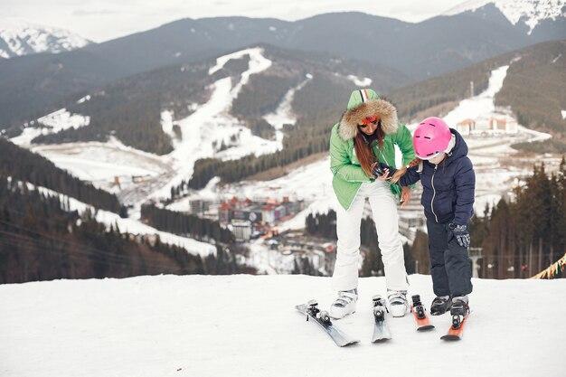Mother with daughter skiing. People in the snowy mountains.