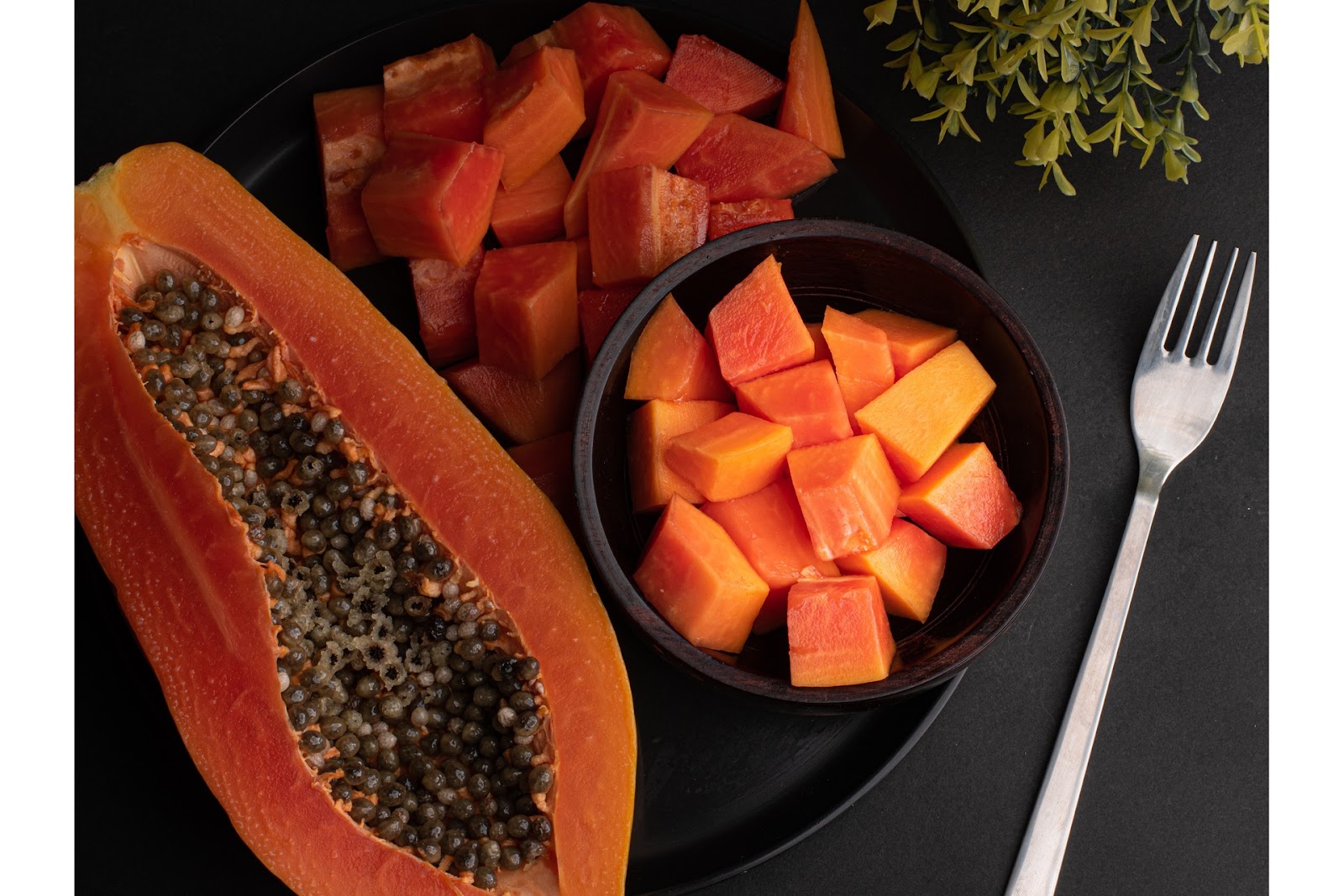 Sliced papaya and a fork - food to get periods early